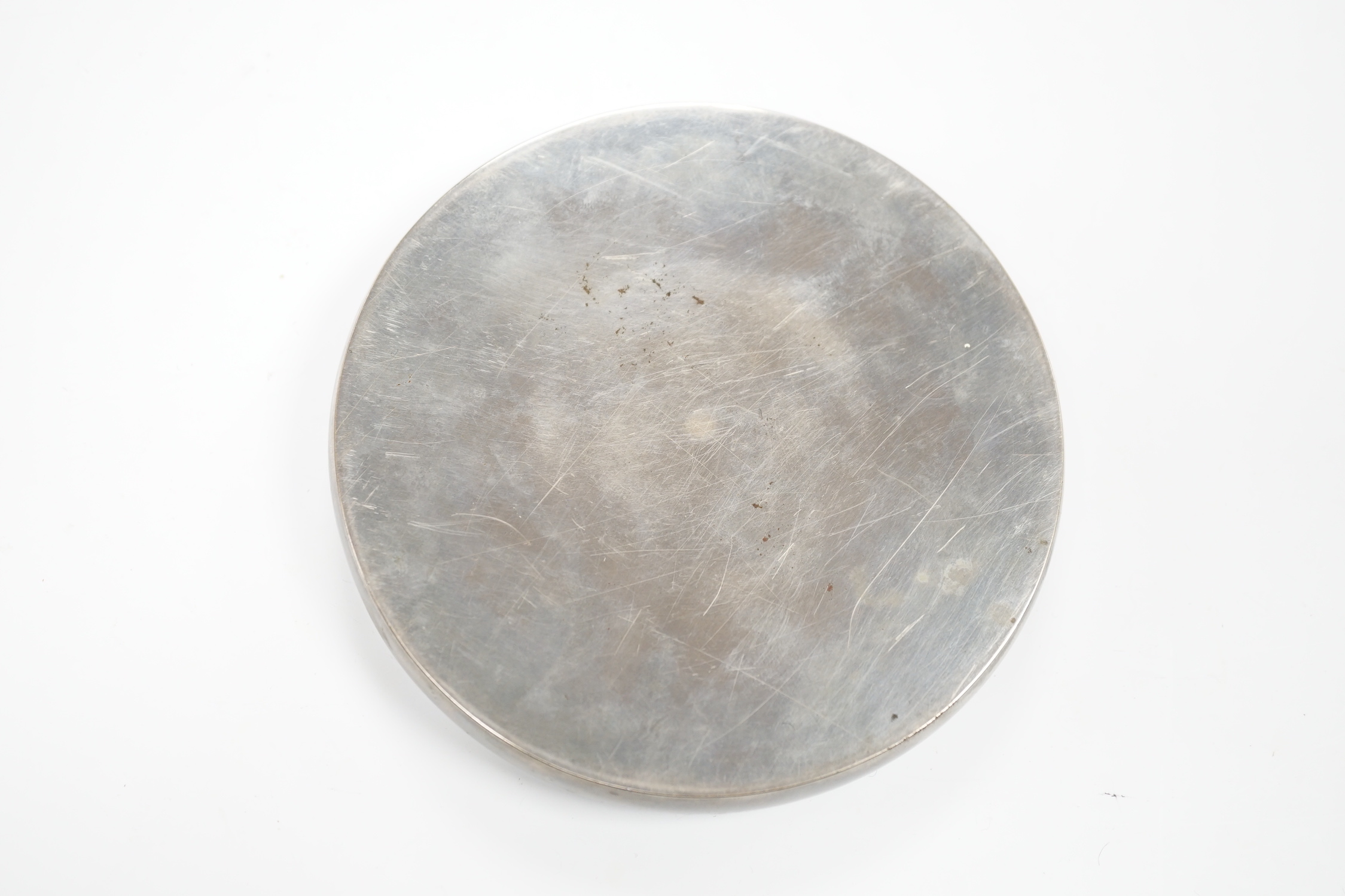 A Japanese cast mirror, housed in a lacquered case, 12cm in diameter